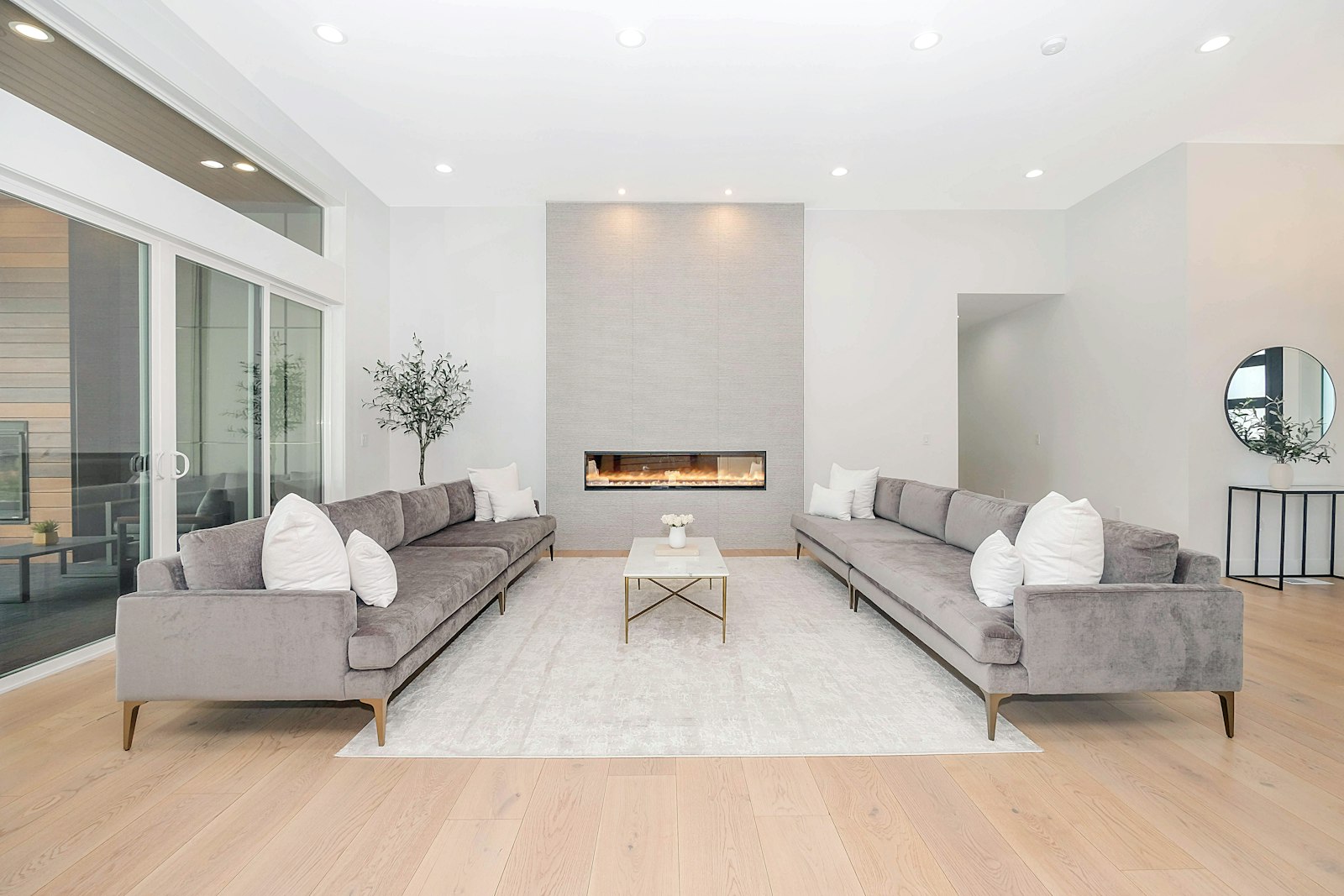 Bright modern living room with soft grey sofas and pale wood flooring